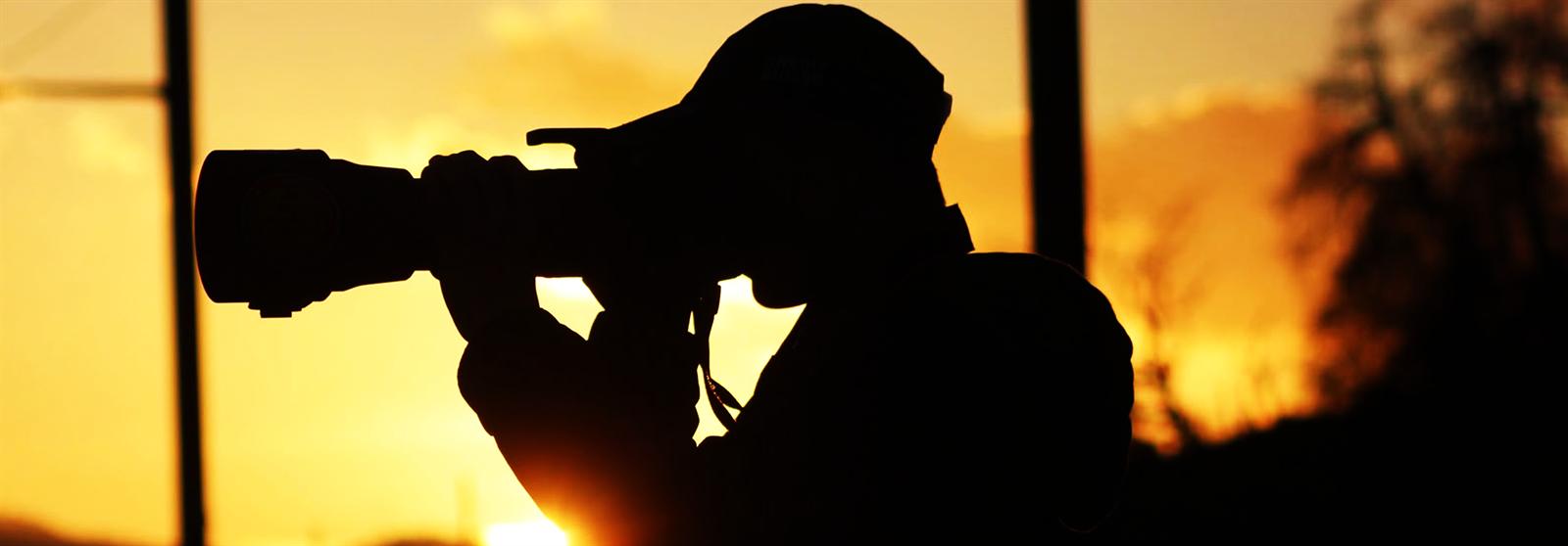 Fotograf im Gegenlicht eines Sonnenuntergangs
